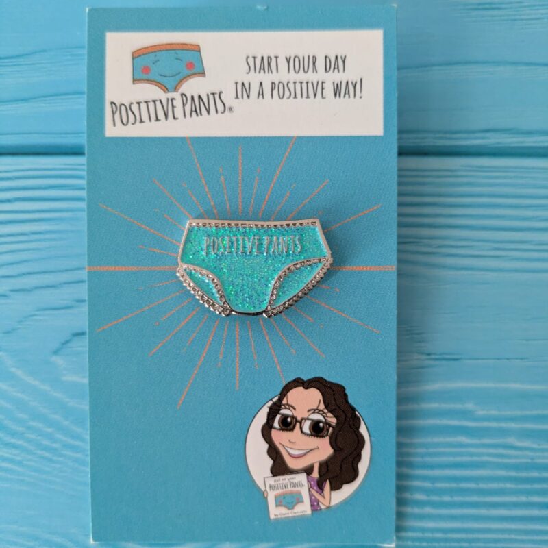 Positive Pants blue glitter enamel pin badge on backing card